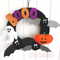 a halloween wreath with bats, ghost and pumpkins on it that says boooo little carabella