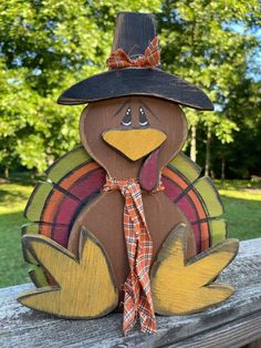 a wooden turkey with a black hat on it's head