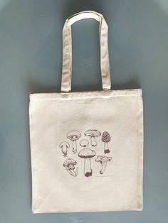 "Introducing my original design - Mushrooms canvas tote bag. Printed by hand with custom mixed colors. * 12.0 oz., 100% heavy canvas * 15\" x 16\" * 20\" self-fabric handles * 10 1/2\" handle drop Thank you for supporting me! © Sydney Sheets, 2021 @thevault.ink : The Vault Design Studio, LLC canvas totes, mushrooms totes, mushroom tote bags, mushrooms, mushroom tote bags, mushroom bags, mushroom canvas totes, mushroom canvas bags, mushroom canvas totes, mushrooms" Vault Design, Pastel Mushroom, Mushroom Canvas, Customized Clothes, Cute Mini Backpacks, Diy Tote, Canvas Totes, Tote Bag Custom, Mini Backpacks