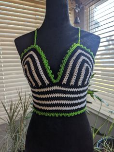 a black and white top with green trim on a mannequin