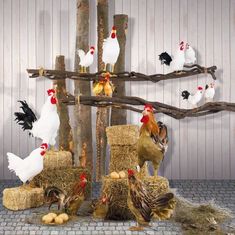 chickens and roosters are standing around hay bales