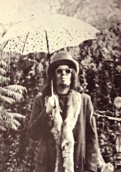 an old black and white photo of a woman holding an umbrella