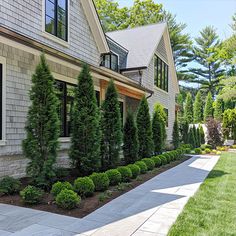 a house that has some bushes in front of it and grass on the ground next to it