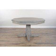 a round concrete table sitting on top of a hard wood floor