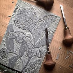 a wooden table topped with lots of crafting supplies next to a knife and some scissors