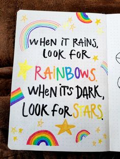 an open notebook with rainbows and stars written on the pages, which are colored in different colors