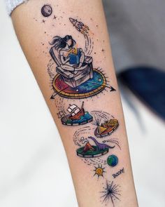 a woman's arm with tattoos on it, including an image of a space shuttle and