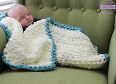 a baby wrapped in a crochet blanket sleeping on a green couch