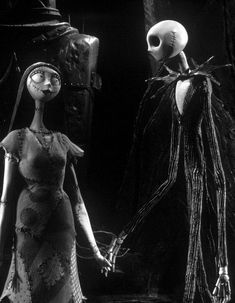 a woman in a dress standing next to a skeleton