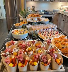 a table filled with lots of food on top of a kitchen counter