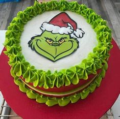 there is a cake decorated with the grin face and green ruffles on top