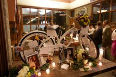 a bicycle with flowers and pictures on the front is surrounded by candles, photos, and other decorations