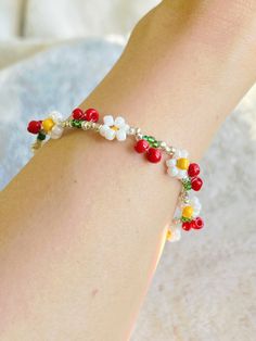 a close up of a person's foot wearing a bracelet with flowers on it