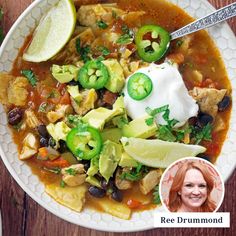 a bowl of mexican chicken soup with sour cream and avocado garnish