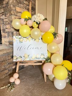 a welcome sign surrounded by balloons and flowers