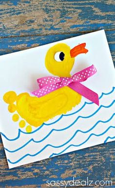 a handmade card with a rubber ducky floating on the water and pink ribbon tied around its neck