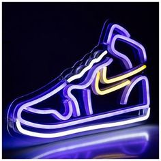 a pair of sneakers with neon lights in the shape of a shoe on a table