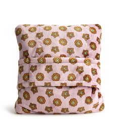 a pink bag with an orange and green flower pattern on the front, sitting on top of a white surface