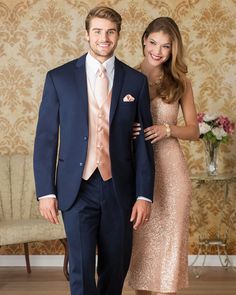 a man and woman in formal wear standing next to each other on a wooden floor