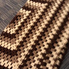 a brown and white crocheted tie laying on top of a blue couch cushion