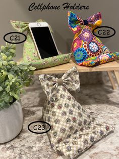 the cell phone holder is next to a potted plant and an iphone on a table