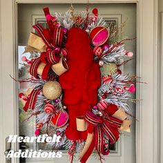 a christmas wreath with red and gold decorations hanging from the front door to give it a festive feel