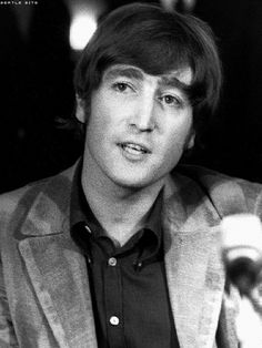 black and white photo of man in suit with microphone