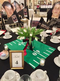 the table is set up for a football themed party with photos and flowers in vases