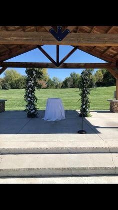 an outdoor ceremony setup with white flowers and greenery on the steps to the aisle