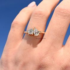 a woman's hand with a three stone ring on top of her left hand