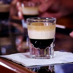 a glass filled with liquid sitting on top of a table