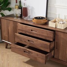 a wooden dresser with drawers and baskets on it's sides, next to a potted plant