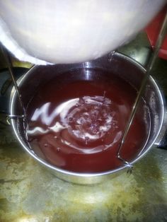 a person pouring liquid into a metal bowl