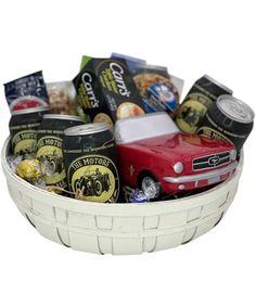 a white basket filled with lots of different types of food and drink items on top of each other