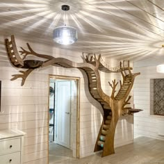 a wooden tree with stairs and birds on it in the middle of a living room