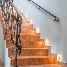 the stairs are made of wood and have metal handrails with lights on them