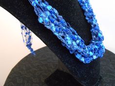 there is a blue beaded necklace on top of a hat