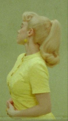 a woman with long blonde hair wearing a yellow dress