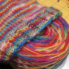 multicolored yarn is sitting on top of a sewing machine