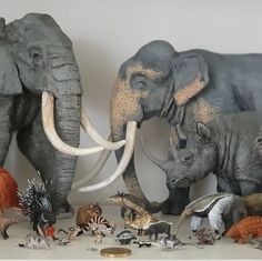 there are many stuffed animals on the shelf together, including elephants and other wild animals