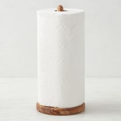 a white toilet paper holder with a wooden handle