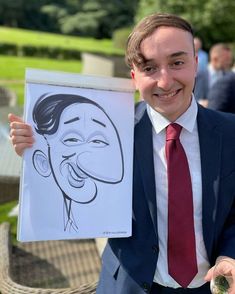 a man in a suit and tie holding up a caricature drawn on paper