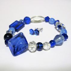 Make a statement with this Chunky beaded bracelet and earrings set! This beautiful bracelet is made with a myriad of blues and clear beads including lampwork glass, faceted crystal, glass, and spacers.  These are all presented on a double strand of Gossamer Floss for a nice firm stretch.  Easy to put on and take off.  This will fit wrists from about 7 to 7.5 inches. The matching earrings are made with Swarovski crystals on nickel free and hypo-allergenic posts with rubber backs.    Thank you so much for looking! I  gladly accept Credit Cards thru Direct Checkout here on Etsy, or PayPal. I ship internationally as well! Combined shipping discounts apply for multiple purchases on the same invoice. Clear Beads, Faceted Crystal, Wedding Jewelry Sets, Sapphire Blue, Glass Crystal, Earrings Set, Matching Earrings, Beautiful Bracelet, Crystal Glass