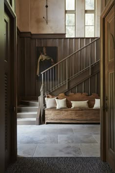 an entryway with wooden paneling and stairs leading up to the second floor area