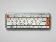 an orange and white keyboard with words on it's backliting keys that read, this is plastic