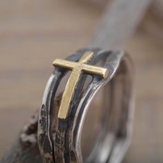 When selecting a gift of faith for a special woman in your life, you cannot go wrong with this sterling silver and gold cross ring. The surface of the ring features a rich oxidized twig texture 9mm wide with a handcrafted 14KT solid gold cross on it. You may add a more personal feeling with a short engraved by hand message on the inside. When completing checkout please write your request and your ring size in the Personalization box. You may ask for a US or non-US size (EU, UK, Swiss, etc). We o Gold Cross Rings With Spiritual Style, Adjustable Cross-shaped Ring For Anniversary, Adjustable Cross Rings With Spiritual Style, Adjustable Cross Shaped Spiritual Rings, Spiritual Cross Shaped Rings For Gift, Gold Sterling Silver Cross Ring, White Gold Cross Ring Gift, Gold Cross Rings In Sterling Silver, Hand Message