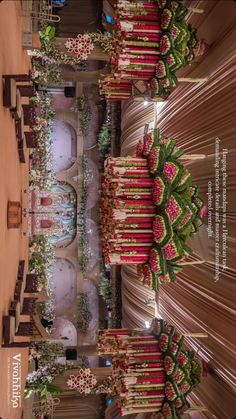 an overhead view of a wedding ceremony with red and pink flowers on the aisle, decorated with greenery