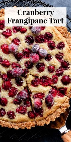 a cranberry frangane tart on a cooling rack with a slice cut out