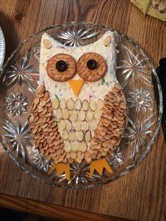 an owl made out of crackers sitting on top of a glass plate