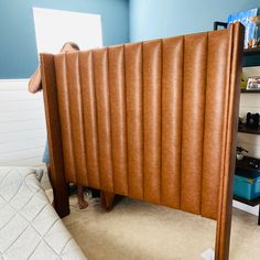 there is a man that is hiding behind the headboard in this bed room with blue walls